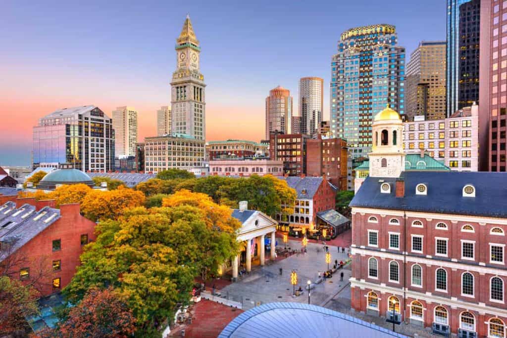 Skyline of Boston Massachusetts including Faneuil Hall and Quincy Market at dusk.
