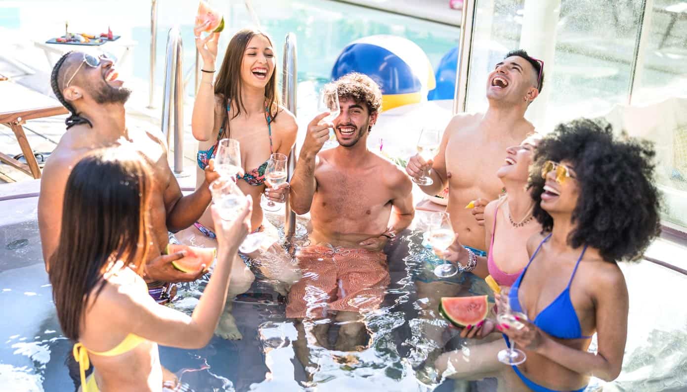 Group of young adults celebrating in a pool.
